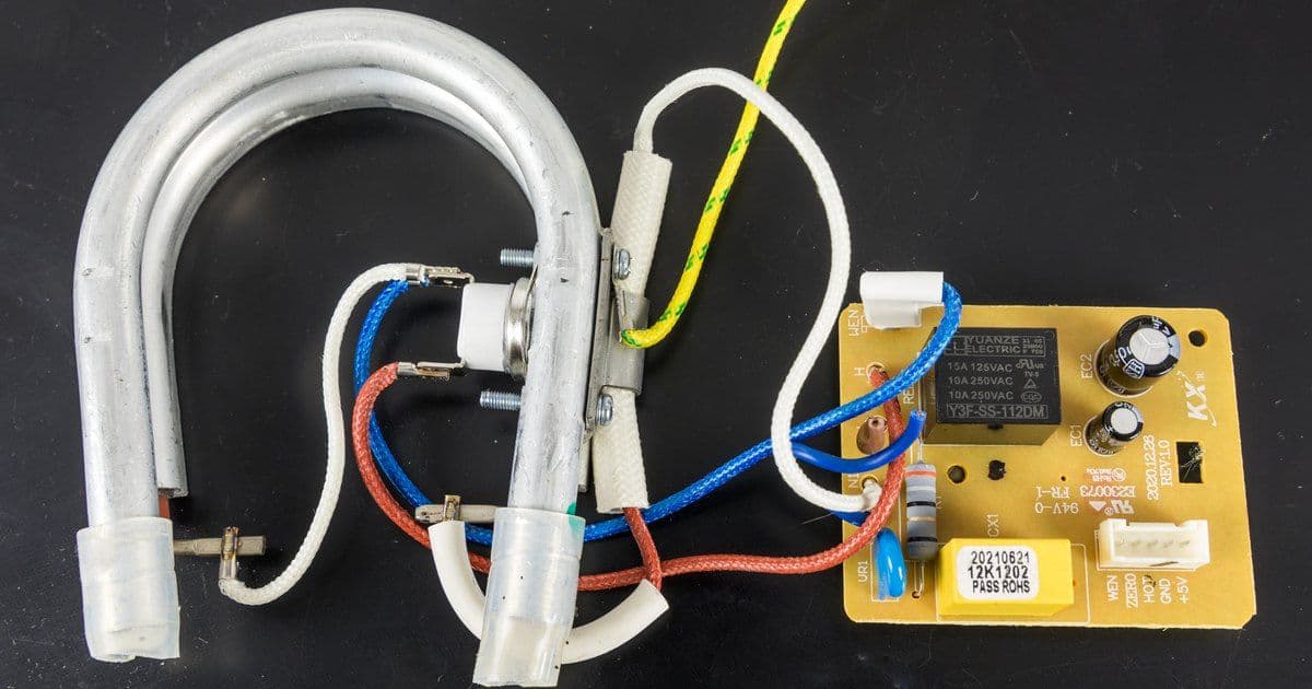 A coffee machine's tubular heating element with braided lead wires connected to its controller board