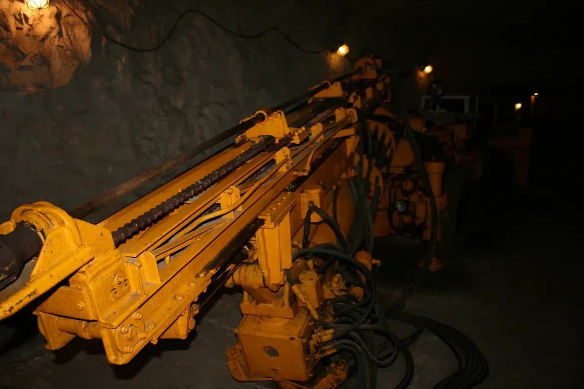 An electro-hydraulic drill jumbo underground, with its drill feeds and hoses