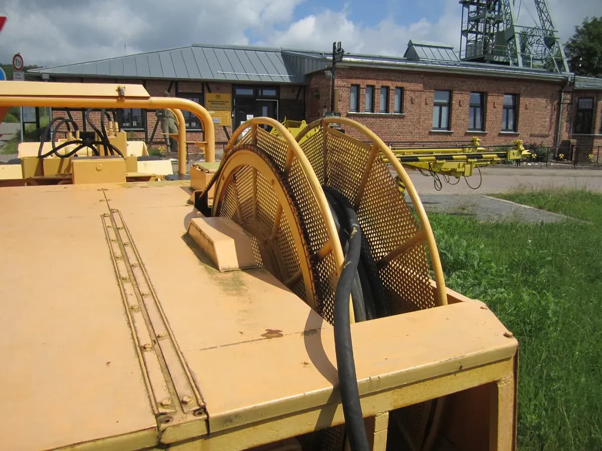 The cable reel at the rear of a historic electric loader, with its trailing cable wound on the drum