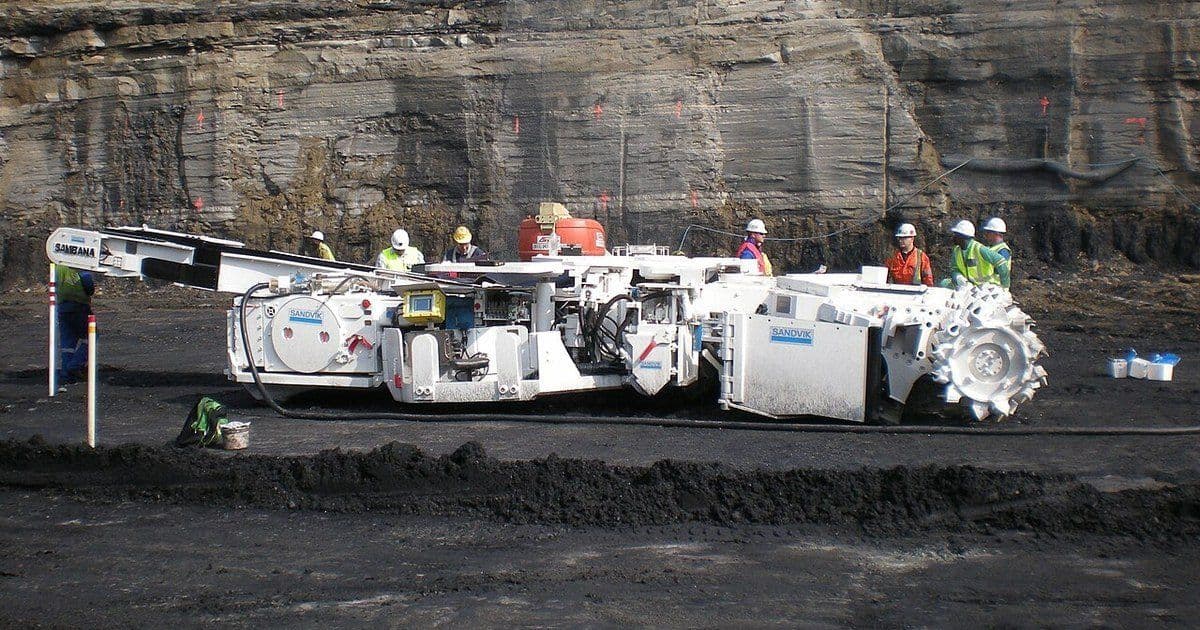 A continuous bolter miner parked in front of a coal highwall at an open-cast mine in Mpumalanga, South Africa