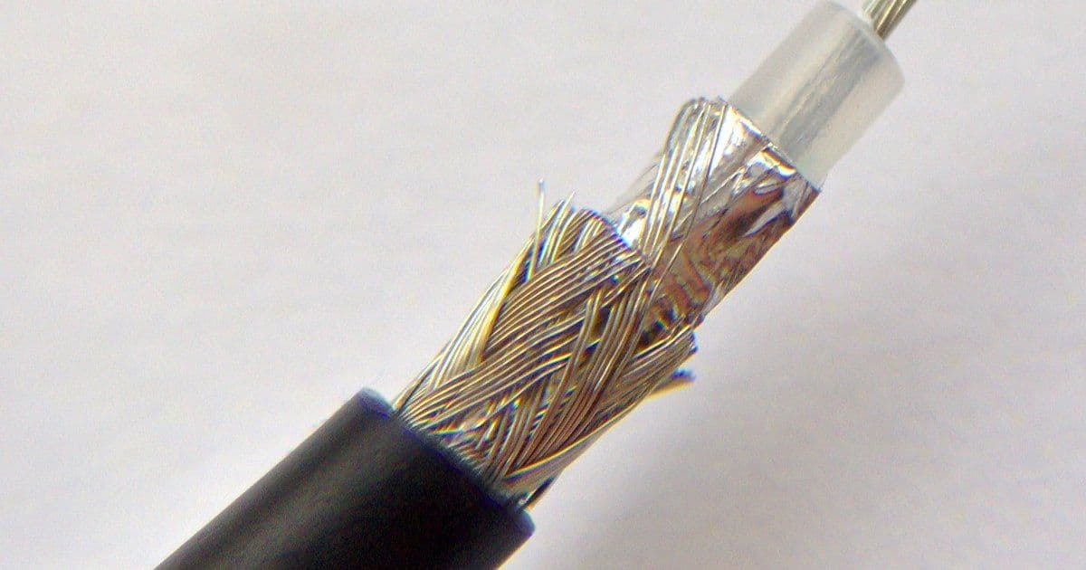 A cut coaxial cable showing its black jacket, a wire braid, a foil layer and the clear insulation around the centre conductor
