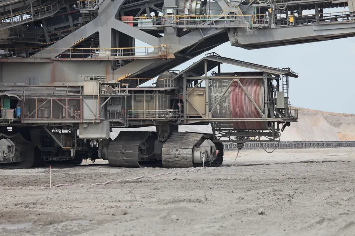 A large drum wound with red power cable on the side of a crawler-mounted mining machine